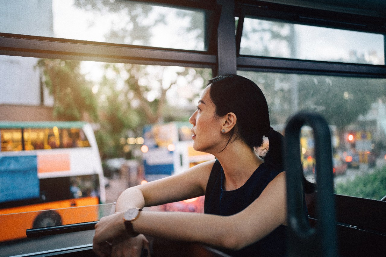 Young woman traveller sightseeing in Hong Kong and enjoying city scene while riding on public transportation in city