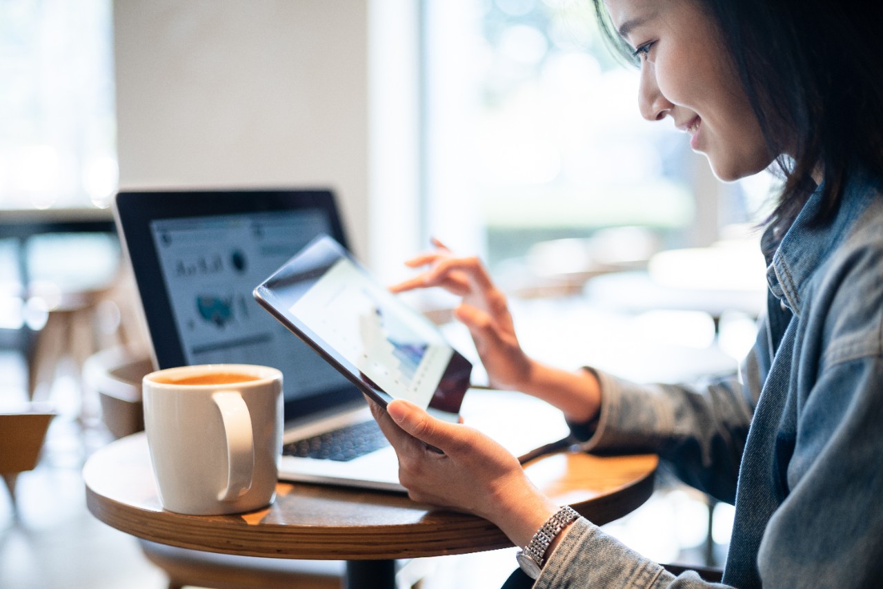 asian female using digital tablet in cafe